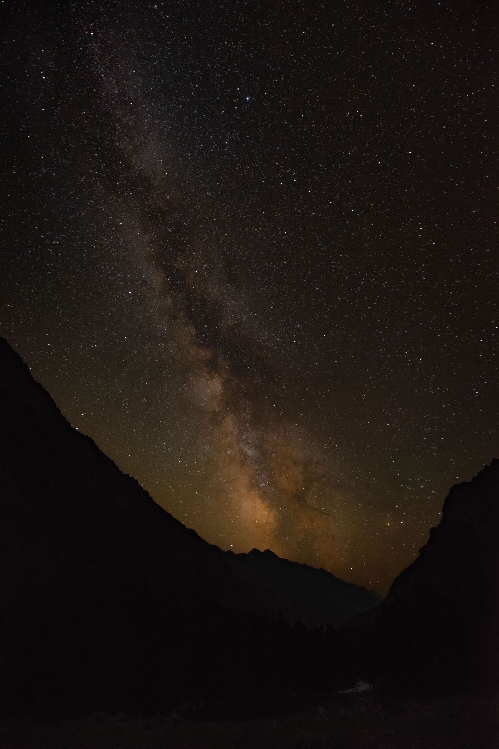 Vía láctea sobre la silueta de una cordillera de montaña, cielo nocturno estrellado