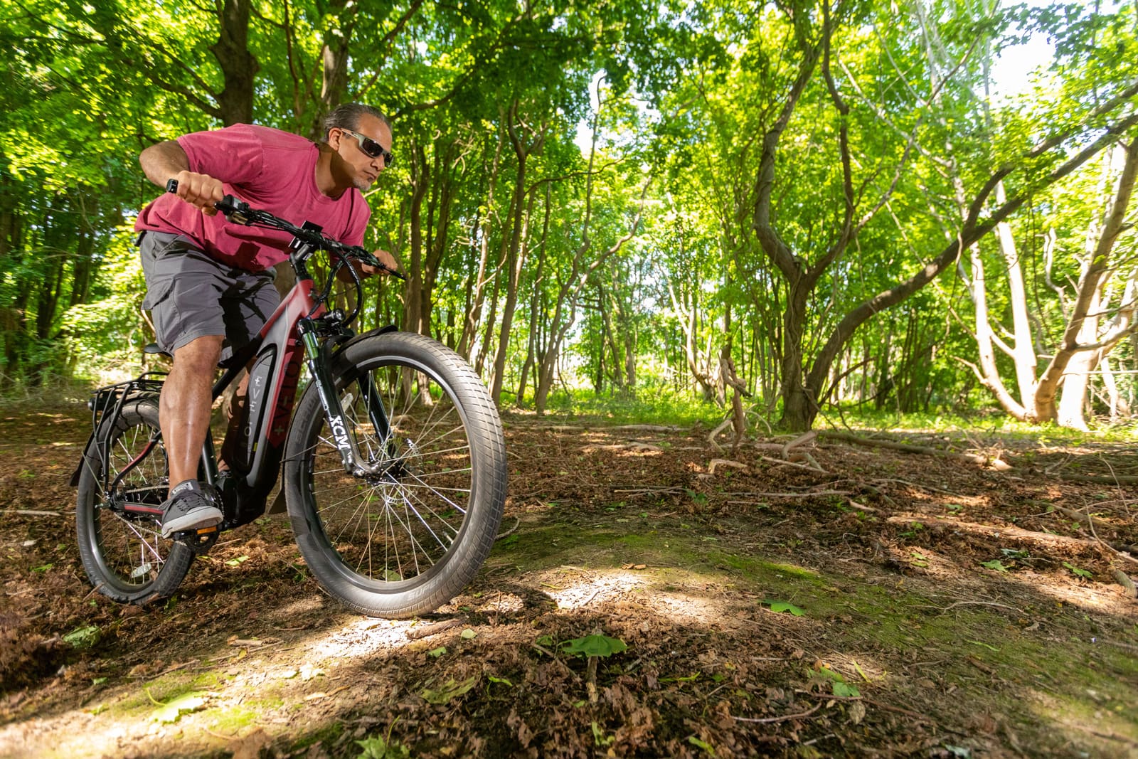 Ciclista preparándose para una ruta guiada en e-bike por un bosque de montaña