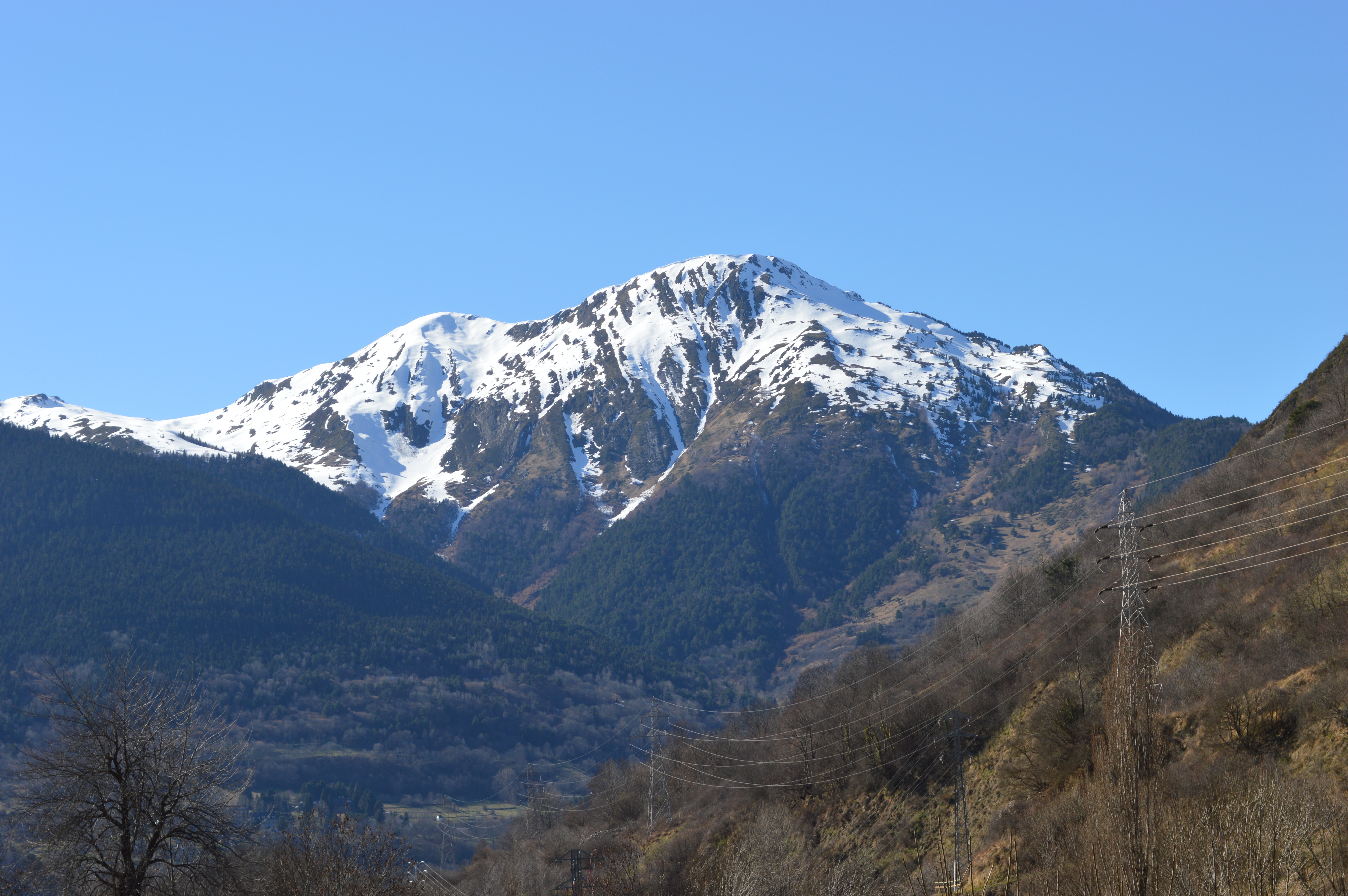 Cima del Montcorbison nevada vista desde el valle, con el pueblo de Vielha al fondo