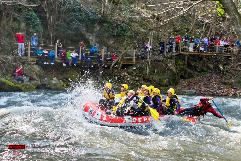 Balsa de rafting descendiendo un rápido con caudal alto
