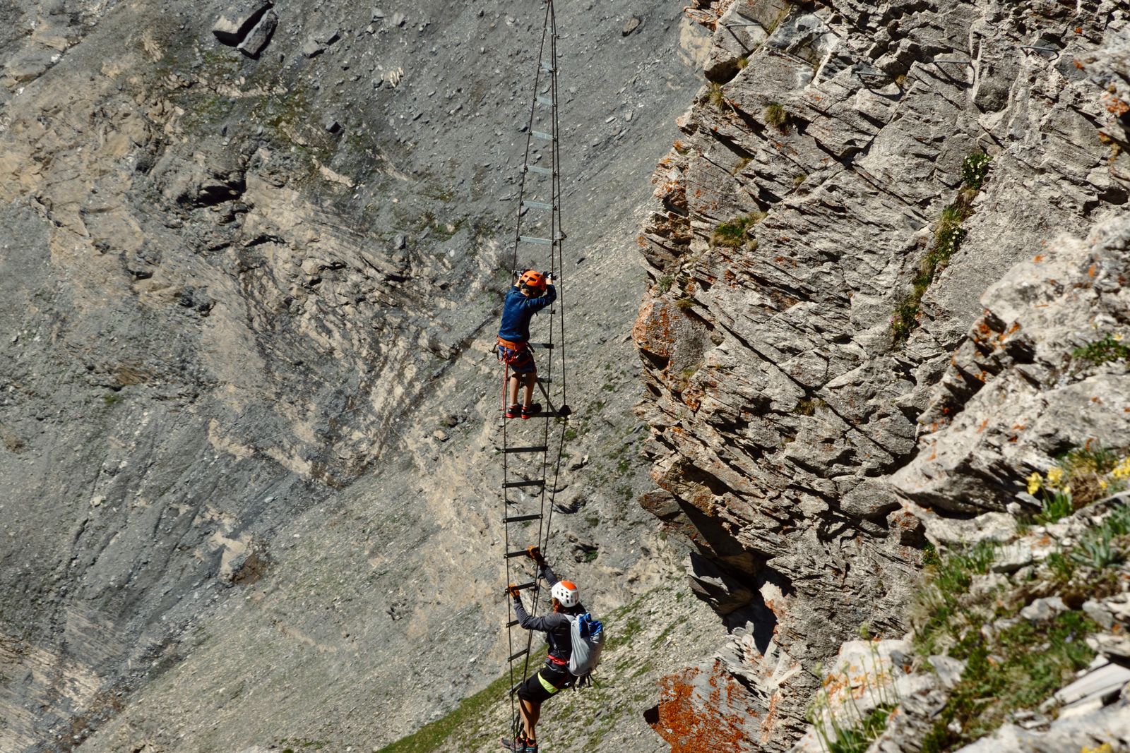 Persona subiendo por una escalera vertical de una vía ferrata