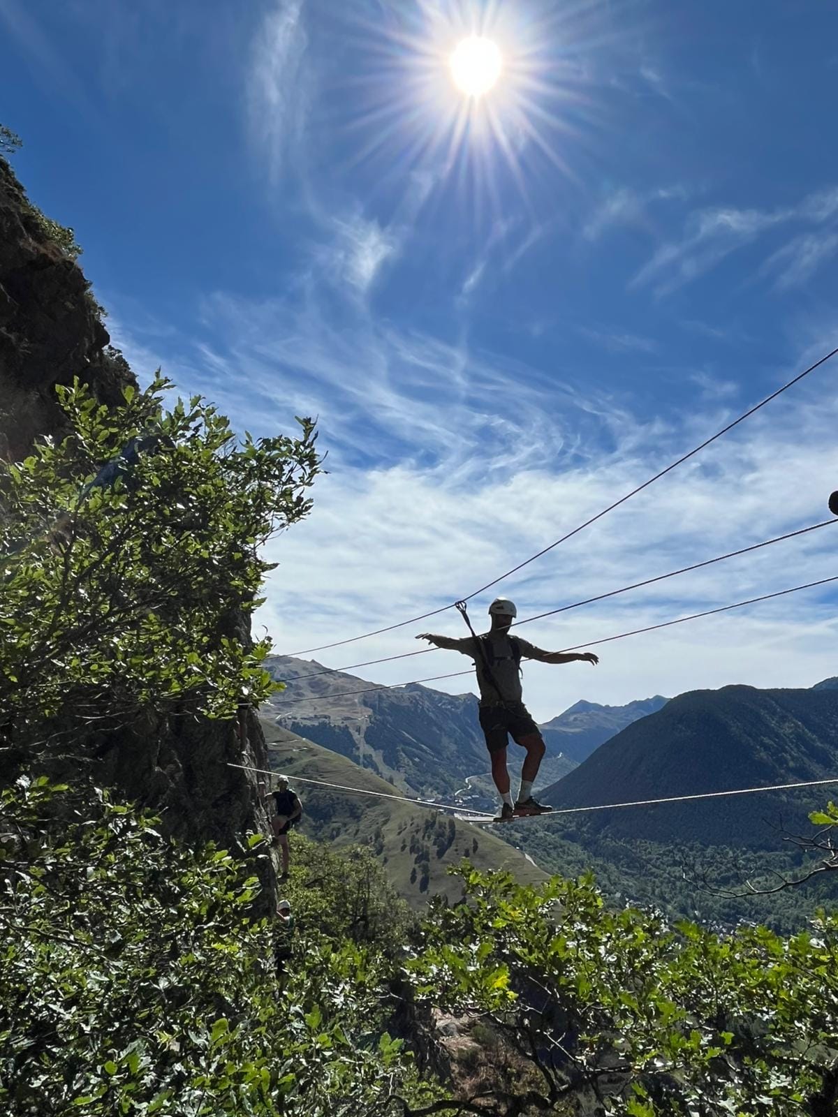 Escalera de peldaños colgante en la vía ferrata de Poi d'Unha, con el valle de Naut Aran al fondo