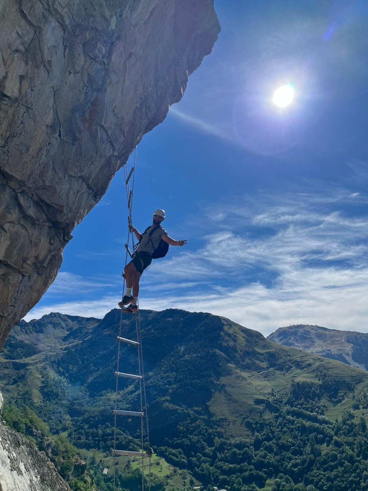 Escalera de peldaños colgante en la vía ferrata de Poi d'Unha, con el valle de Naut Aran al fondo