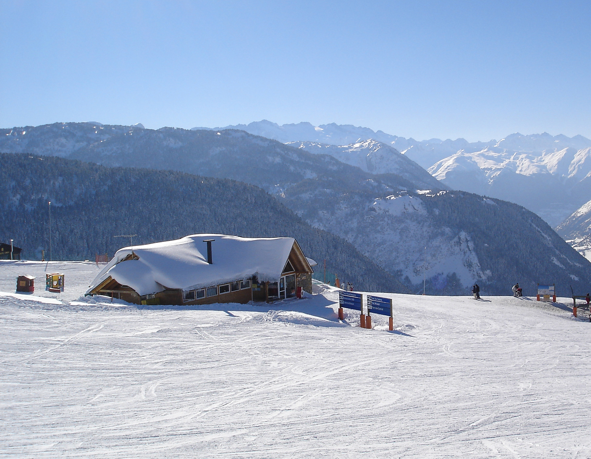Estación de Baqueira Beret nevada con pistas y refugio de montaña
