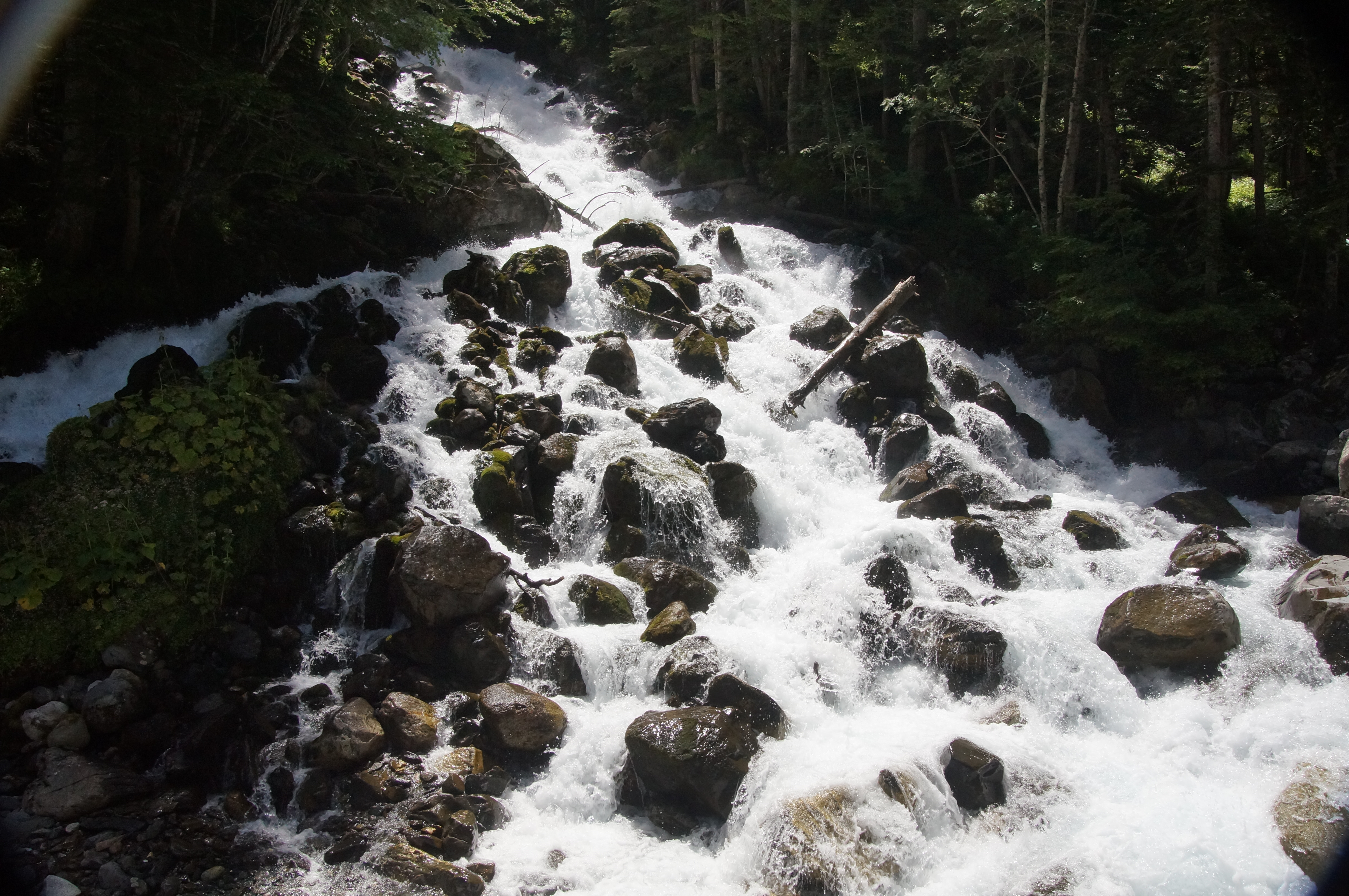 Cascada de Uelhs deth Joèu entre rocas y bosque en la Artiga de Lin