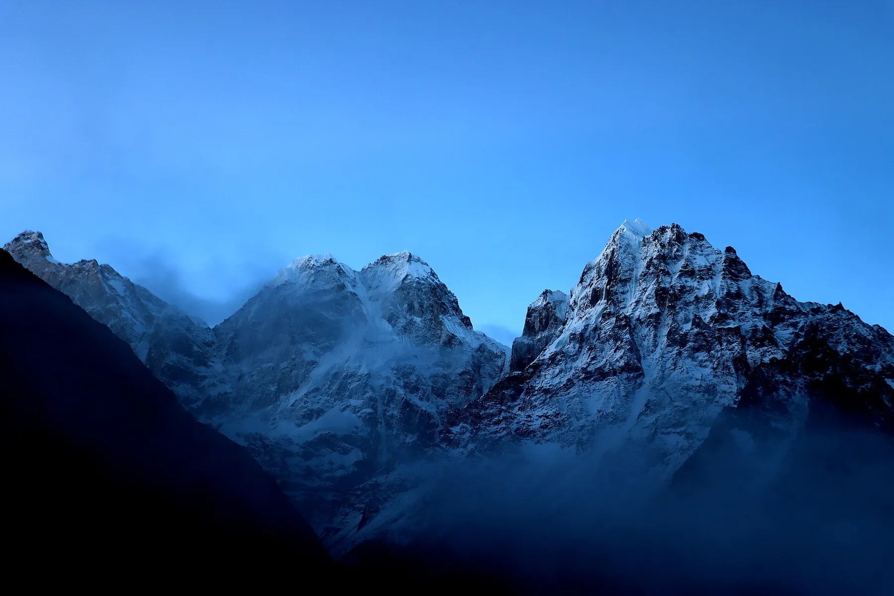 Cumbres nevadas del Jannu y el Kumbhakarna sobre un valle en sombra, con cielo azul intenso